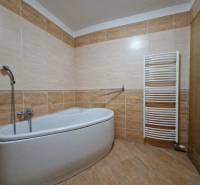 Bathroom with a bathtub and a ladder radiator in a holiday apartment.