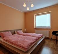 Bedroom with a double bed and wooden furniture in a Holiday Apartment.