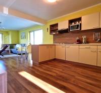 Bright kitchen with a sofa in the Holiday Apartment, open space with wooden flooring.