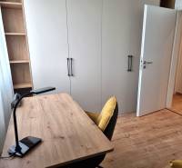 A workspace with a wooden desk and chair in a 3-room apartment.