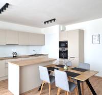 A kitchen in a 3-room apartment with a wooden table and modern appliances.