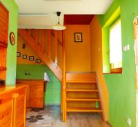A colorful cabin interior with a staircase and wooden furniture.