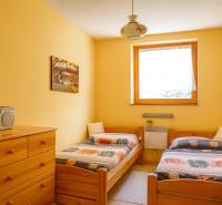 Double room in a cabin with wooden furniture and a radio on the dresser.