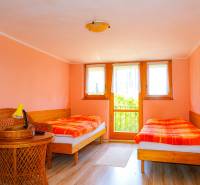 A double room in a cottage with wicker furniture and pastel-colored walls.