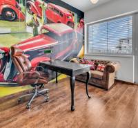 Office room with a leather chair, desk, and an artistic wall painting in a 4-room apartment.