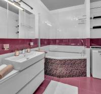 Bathroom with a shower, cabinet, and washing machine in a 4-room apartment.