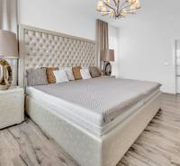 Luxury bedroom with a large bed and a stylish chandelier in a 4-room apartment.