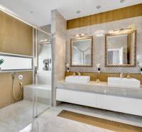 A luxurious bathroom with two sinks, mirrors, and a shower in a 4-room apartment.