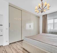 Bedroom with a wardrobe and a chandelier in a 4-room apartment.