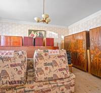 A room in a family house with antique furniture and decorative wallpaper.