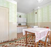 A kitchen in a family house with a dining table, chairs, and a kitchen unit.