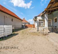 The courtyard of a family house in Jahodná with a bicycle and large water tanks.