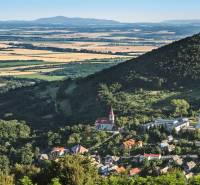 Panoramic view of a village in a valley, surrounded by forests and fields. Land suitable for living.
