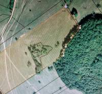 Aerial view of a plot surrounded by forest, ideal for living and investment.