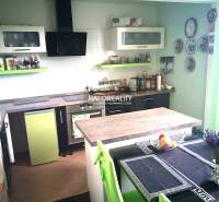 A kitchen in a family house with green and white cabinets and a dining table.