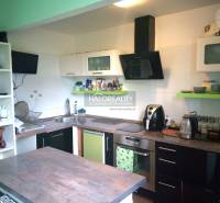 A kitchen in a family house with shelves, appliances, and an extractor hood.