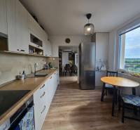 A kitchen in a 4-room apartment with light wooden furniture and a view from the window.