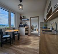 A kitchen in a 4-room apartment with light seating and a view of the surroundings.