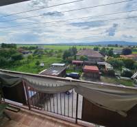 The view from the apartment in Kočovce of gardens, houses, and hills in the distance.