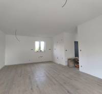 Interior of a family house with wooden flooring, white walls, and preparation for electrical installation.