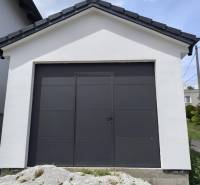 A family house in Malé Krštenany with a white garage and dark doors.