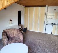 Living room in a two-room apartment with a kitchenette and a comfortable armchair.