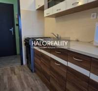 A studio apartment with a kitchenette in wooden decor and ceramic tiles.