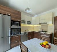 A kitchen in a 4-room apartment with wooden cabinets and stainless steel appliances.