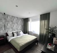 Bedroom in a 4-room apartment with a comfortable bed, a plant, and furniture.