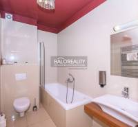 Bathroom in a 2-room apartment with a bathtub, sink, toilet, and towel rack.