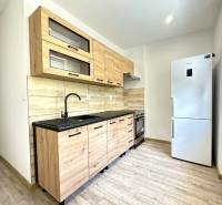 A kitchen in a 2-room apartment with wooden cabinets and modern equipment.