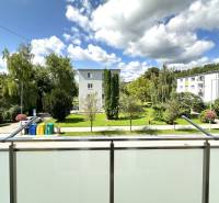 View from the balcony of greenery between apartment buildings on Obrancov Mieru Street in Púchov.