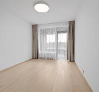 An empty room with wooden flooring, curtains, and a window in a 2-room apartment.