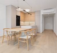 Dining area with stylish chairs and a kitchen in a 2-room apartment.