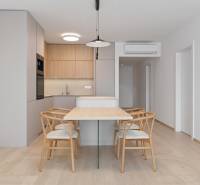 Dining table with four chairs and a kitchen in a 2-room apartment.