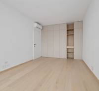 An empty room with a wooden floor, built-in wardrobe, and air conditioning in a 2-room apartment.