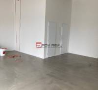 An empty space with a concrete floor and doors in commercial premises.