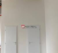 Double white doors in commercial premises with a concrete ceiling.