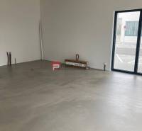 Unfurnished commercial spaces with large windows and concrete flooring.