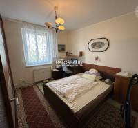 Bedroom in a 3-room apartment with a bed, painting, and carpets, suitable for living.