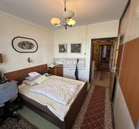 Bedroom in a 3-room apartment with a built-in wardrobe, computer desk, and wall decoration.