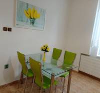 Glass dining table with green chairs in a family house.