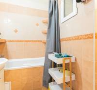 Bathroom with a bathtub, sink, and storage space in a 2-room apartment.