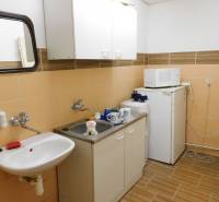 Interior of a kitchenette with a sink, microwave, and refrigerator in warehouse and hall spaces.