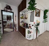 A hallway in a 3-room apartment with decorations and a view into the living room.