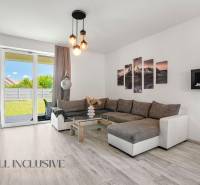 A living room in a family house with a comfortable sofa and glass doors leading to the garden.