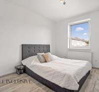 A bedroom in a family house with a single bed and a window, light wooden floors.