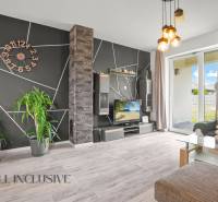 Living room in a family house with a black geometric wall, television, and houseplants.