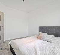 A bedroom in a family house with an upholstered headboard and wooden doors.