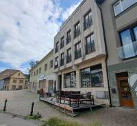 The building on Mostová Street in Ružomberok with a terrace and surrounding historical structures.